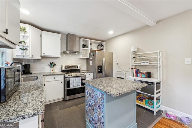 kitchen with stainless steel appliances, white cabinetry, a kitchen island, and wall chimney exhaust hood