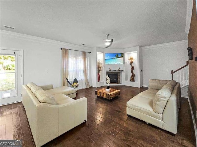 living room with a textured ceiling, dark hardwood / wood-style floors, and crown molding