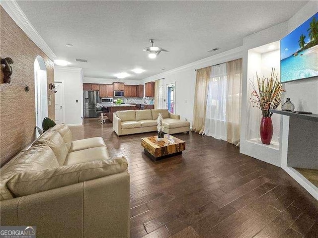 living room with dark hardwood / wood-style flooring, a textured ceiling, and ornamental molding