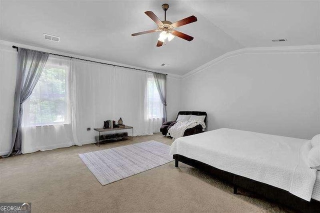 carpeted bedroom with multiple windows, ceiling fan, and lofted ceiling