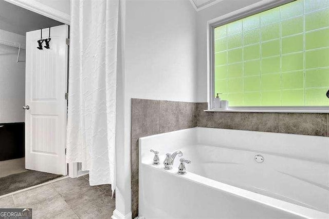 bathroom featuring tile patterned flooring, plenty of natural light, and a tub