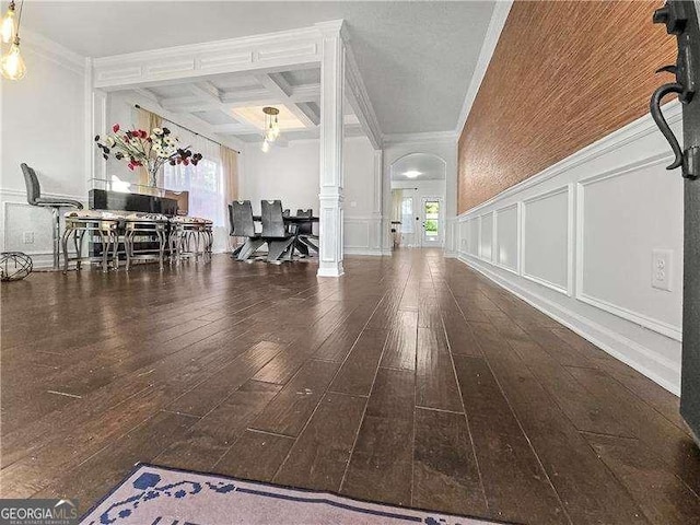 interior space with dark hardwood / wood-style flooring, ornate columns, ornamental molding, coffered ceiling, and beam ceiling