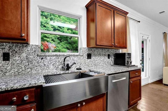 kitchen with backsplash, crown molding, dishwasher, and light stone counters