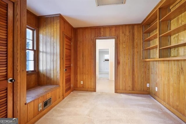 mudroom with wooden walls and light colored carpet