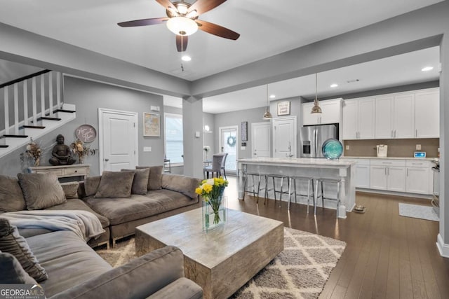 living room featuring dark hardwood / wood-style floors and ceiling fan