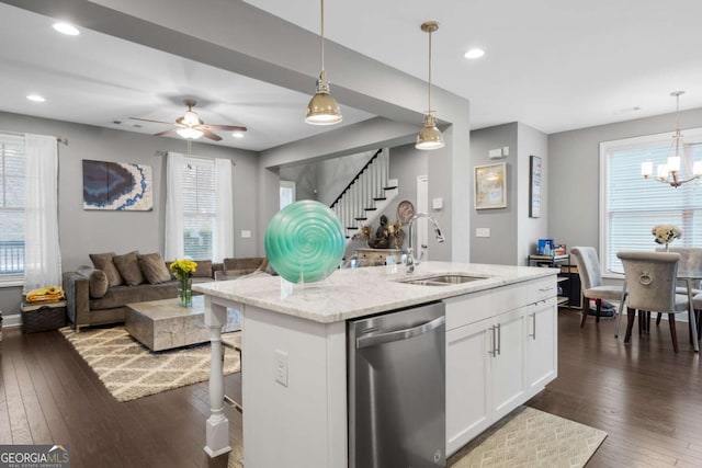 kitchen with white cabinets, sink, hanging light fixtures, stainless steel dishwasher, and light stone counters