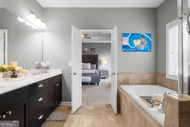 bathroom featuring vanity, tiled bath, ceiling fan, and a healthy amount of sunlight