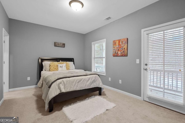 bedroom featuring light colored carpet, access to outside, and multiple windows