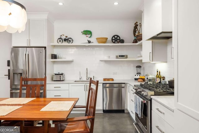 kitchen featuring backsplash, crown molding, sink, white cabinetry, and stainless steel appliances