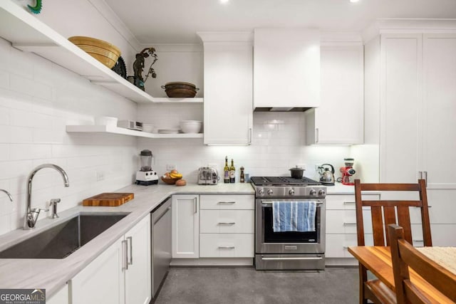 kitchen with white cabinets, sink, light stone countertops, tasteful backsplash, and stainless steel appliances