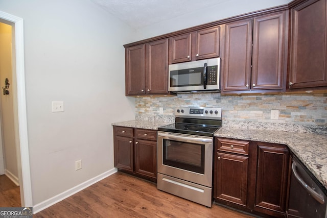kitchen featuring backsplash, appliances with stainless steel finishes, and wood finished floors