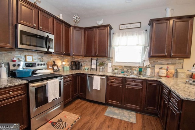 kitchen with stainless steel appliances, light hardwood / wood-style flooring, tasteful backsplash, and sink