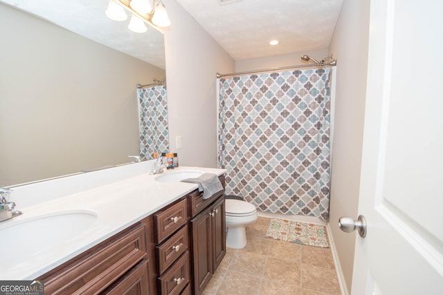 bathroom featuring a sink, a shower with shower curtain, double vanity, and toilet
