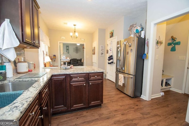 kitchen featuring hanging light fixtures, stainless steel fridge with ice dispenser, dark hardwood / wood-style floors, kitchen peninsula, and a chandelier