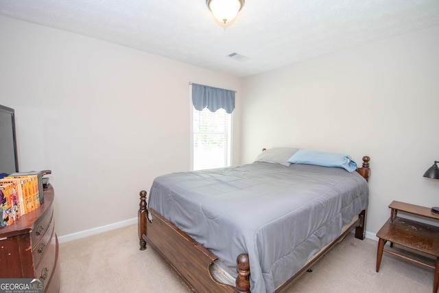bedroom with light carpet, visible vents, and baseboards
