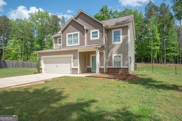view of front of property with concrete driveway, stone siding, an attached garage, fence, and a front yard