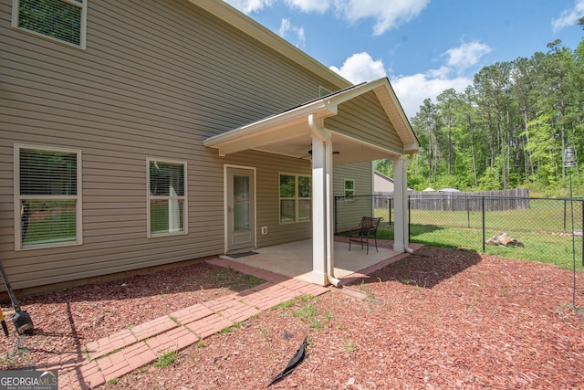 rear view of property featuring fence, a patio area, and a ceiling fan