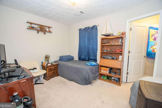 bedroom featuring light colored carpet and a textured ceiling