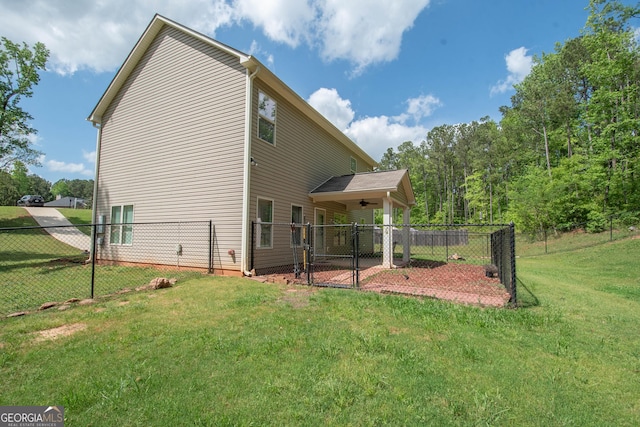 back of house with a gate, a yard, ceiling fan, and fence private yard