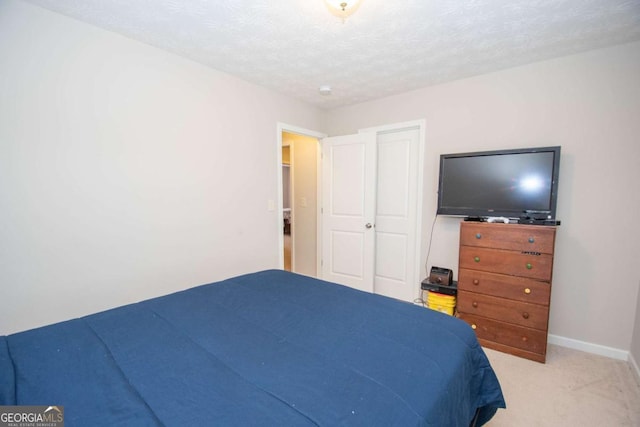 bedroom with a textured ceiling and light colored carpet