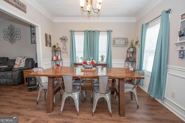 dining area with dark hardwood / wood-style floors, ornamental molding, and an inviting chandelier