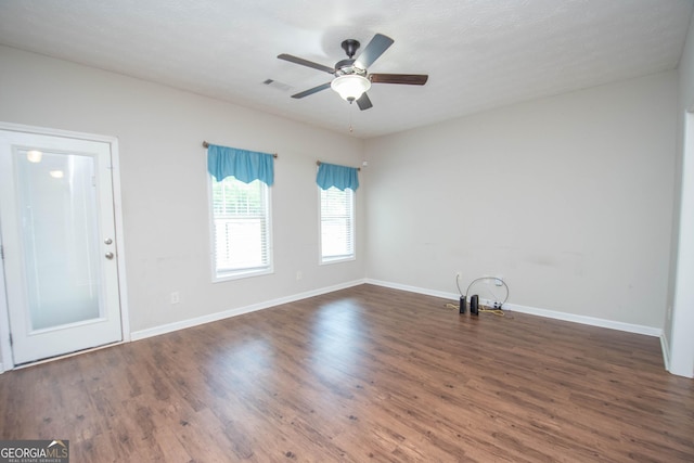 interior space with visible vents, baseboards, wood finished floors, and ceiling fan