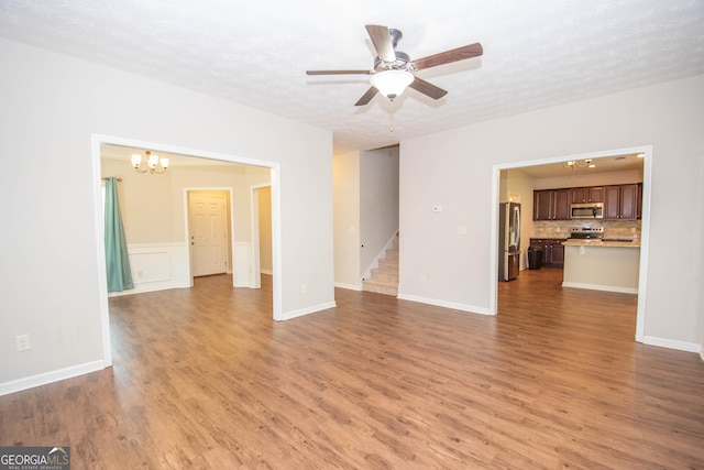 unfurnished living room featuring light wood-style floors and ceiling fan with notable chandelier
