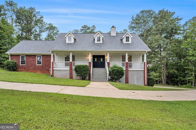 cape cod house with covered porch and a front yard