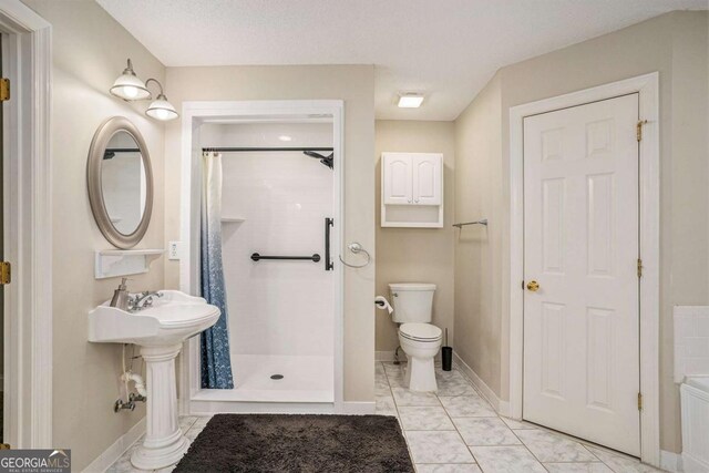 bathroom with a shower with curtain, a textured ceiling, and toilet