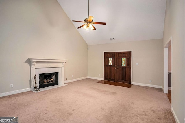 unfurnished living room featuring ceiling fan, light colored carpet, high vaulted ceiling, and a tiled fireplace