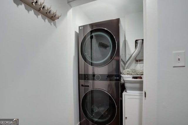 clothes washing area with stacked washer and clothes dryer