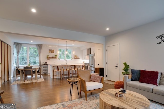 living room featuring sink and light hardwood / wood-style flooring