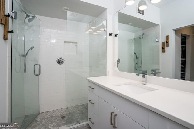 bathroom with vanity and a shower with door