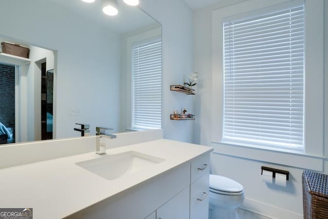 bathroom featuring vanity, toilet, and plenty of natural light