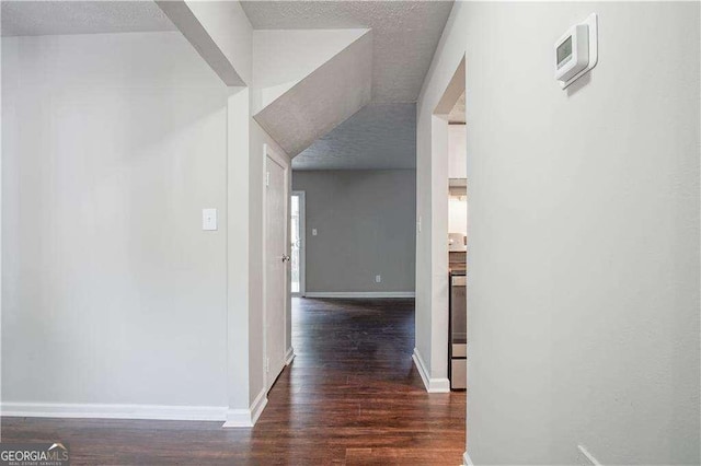 hall featuring dark hardwood / wood-style floors and a textured ceiling