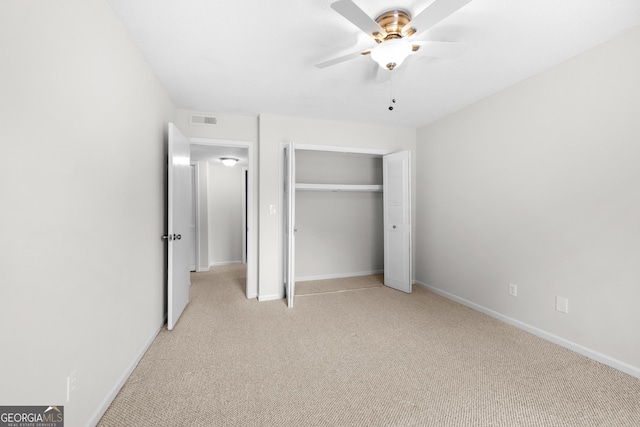 unfurnished bedroom with ceiling fan, light colored carpet, and a closet