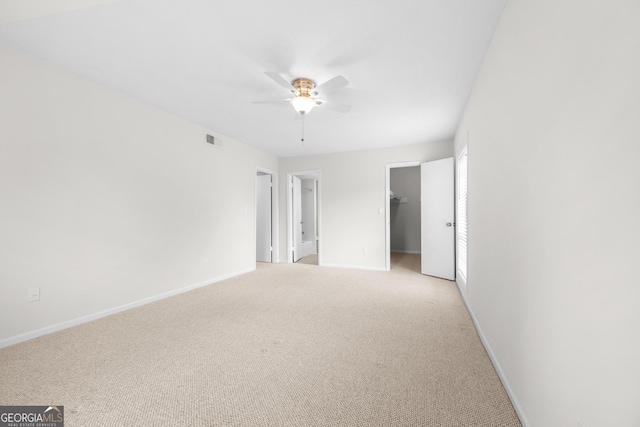 empty room featuring ceiling fan and light colored carpet