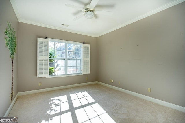 carpeted spare room with ceiling fan and ornamental molding