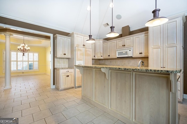 kitchen with hanging light fixtures, light stone counters, backsplash, decorative columns, and a chandelier