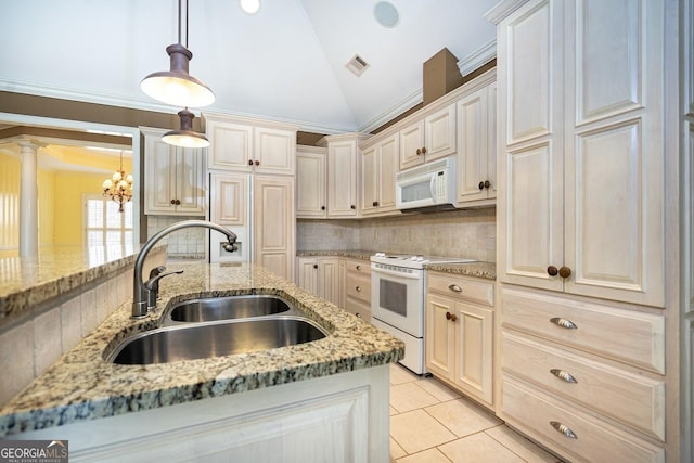 kitchen featuring lofted ceiling, sink, white appliances, and hanging light fixtures