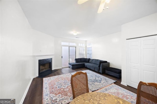 living room with dark hardwood / wood-style flooring and ceiling fan