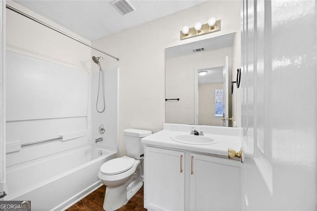 full bathroom featuring shower / bathing tub combination, hardwood / wood-style floors, a textured ceiling, toilet, and vanity