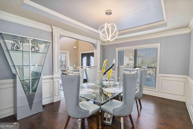 dining space with ornamental molding, dark hardwood / wood-style floors, a raised ceiling, and french doors