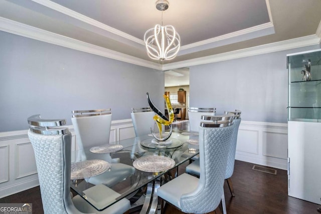 dining space featuring ornamental molding, dark wood-type flooring, and a chandelier