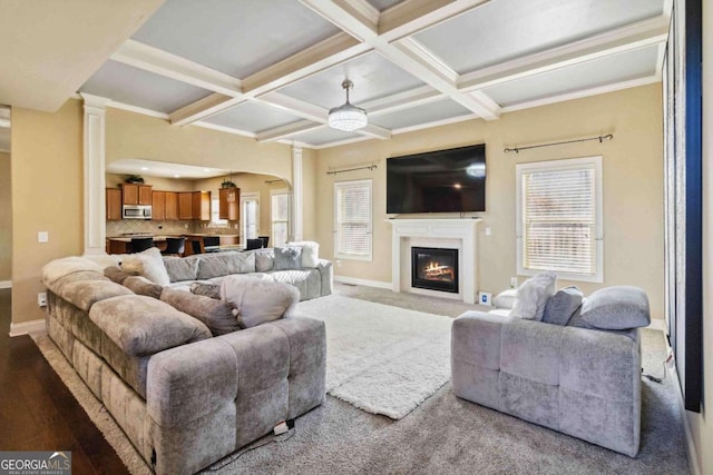 living room with coffered ceiling, beam ceiling, wood-type flooring, and ornamental molding