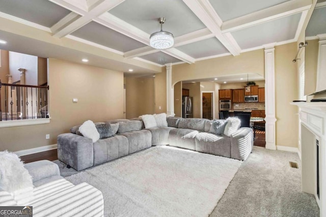 living room featuring decorative columns, coffered ceiling, ornamental molding, light colored carpet, and beamed ceiling