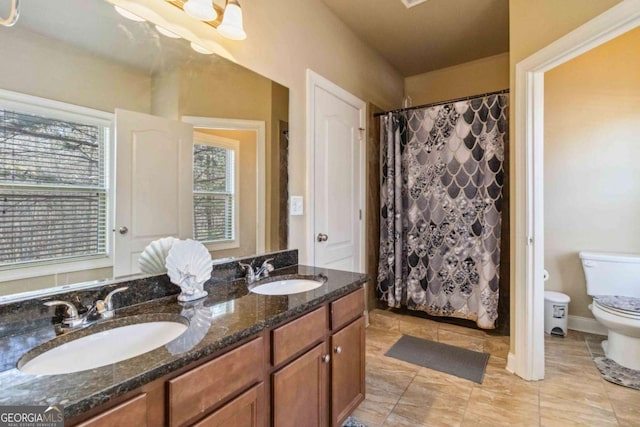 bathroom featuring plenty of natural light, toilet, curtained shower, and vanity