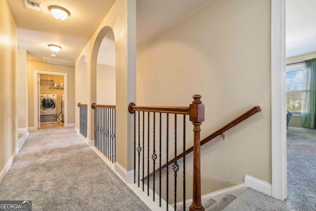 hallway with light colored carpet and independent washer and dryer