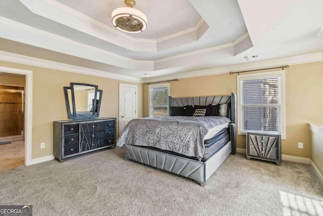 carpeted bedroom featuring multiple windows, crown molding, ensuite bath, and a raised ceiling