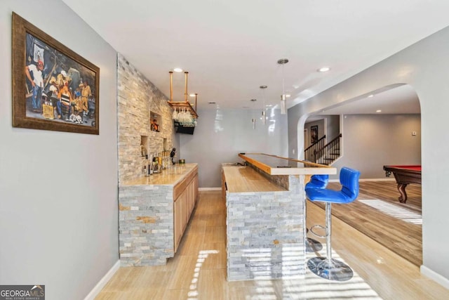 bar featuring light brown cabinetry, pool table, and decorative light fixtures